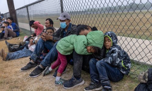 Coraz większym problemem – obok zwiększającej się liczby dorosłych imigrantów, próbujących legalnie lub nielegalnie przekroczyć amerykańską granicę – jest również rekordowa i rosnąca wciąż liczba dzieci, które bez opiekunów trafiają na amerykańską stronę. Potem imigranci z Ameryki Środkowej czekają na rozpatrzenie ich próśb o wjazd do USA przez agentów Straży Granicznej w pobliżu granicy z Meksykiem. 10 kwietnia 2021 r. w La Joya w Teksasie. Fot. John Moore / Getty Images