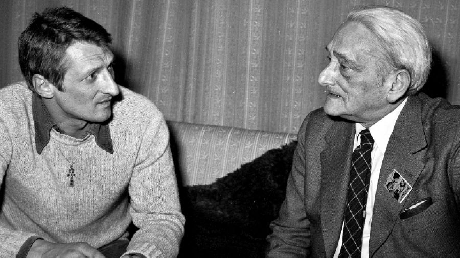 Warszawa, kwiecień 1980. „Puls” – jeden z najważniejszych podziemnych pism społeczno-kulturalnych, wydawanych w PRL w tzw. drugim obiegu, czyli poza zasięgiem cenzury. Przyznawało nagrodę literacką, której pierwszym laureatem był Marian Brandys. Na zdjęciu pisarz wraz z poetą, taternikiem, opozycjonistą i współzałożycielem „Pulsu” Jackiem Bierezinem (po lewej), podczas wręczenia nagrody Puls’80 w mieszkaniu Brandysa i jego żony aktorki Haliny Mikołajskiej przy ul. Marszałkowskiej. Fot. PAP/Tomasz Michalak