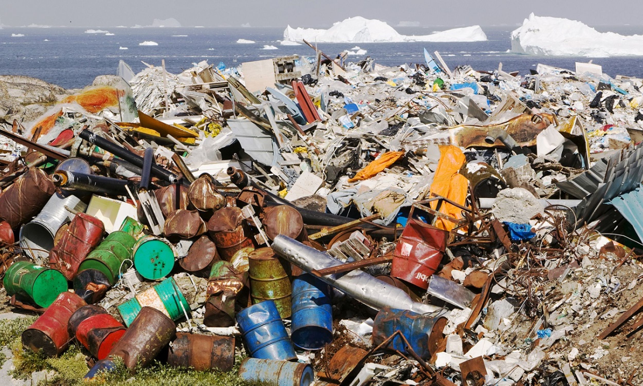 Beczki po ropie wyrzucone w okolicy miasta Ilulissat w Grenlandii, w tle góry lodowe Icefjord w lipcu 2008. Zdjęcie Ashleya Coopera, którego potem aresztowano w Chinach za fotografowanie niszczycielskich skutków zmian klimatu. 54-latek obrazował książkę, opisującą efekty globalnego ocieplenia od Alaski, gdzie rozpoczął podróż, do Boliwii, gdzie skończył. 14 lat wcześniej był świadkiem, jak z powodu tych zmian domy utraciło 600 mieszkańców Alaski. Fot. Ashley Cooper/Barcroft Media via Getty Images