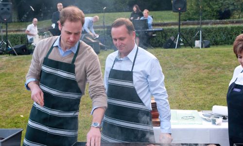 Wellington, Nowa Zelandia, 18 stycznia 2010 r. Książę William i John Key, premier Nowej Zelandii, przygotowują mięso na grillu w Premiere House podczas pierwszej wizyty Anglika – drugiego w kolejności następcy tronu Wielkiej Brytanii – w kraju na antypodach. Fot. Samir Hussein / WireImage