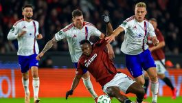 Na zdjęciu trzech piłkarzy Rakowa w białych koszulkach i niebieskich spodenkach. Przed nimi upadający piłkarz Slavii ubrany na borodowo.