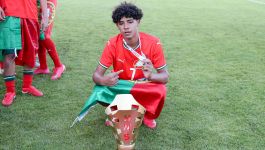 Cristiano Ronaldo junior (fot. Getty Images) Cristiano Ronaldo Junior świętuje zwycięstwo z drużyną Portugalii, prezentując złoty medal i trofeum turnieju WFS. W czerwonej koszulce z numerem 17 i owinięty flagą narodową, dumnie wskazuje na swój sukces – pierwszy krok w reprezentacyjnej karierze U16 (fot. Getty Images)