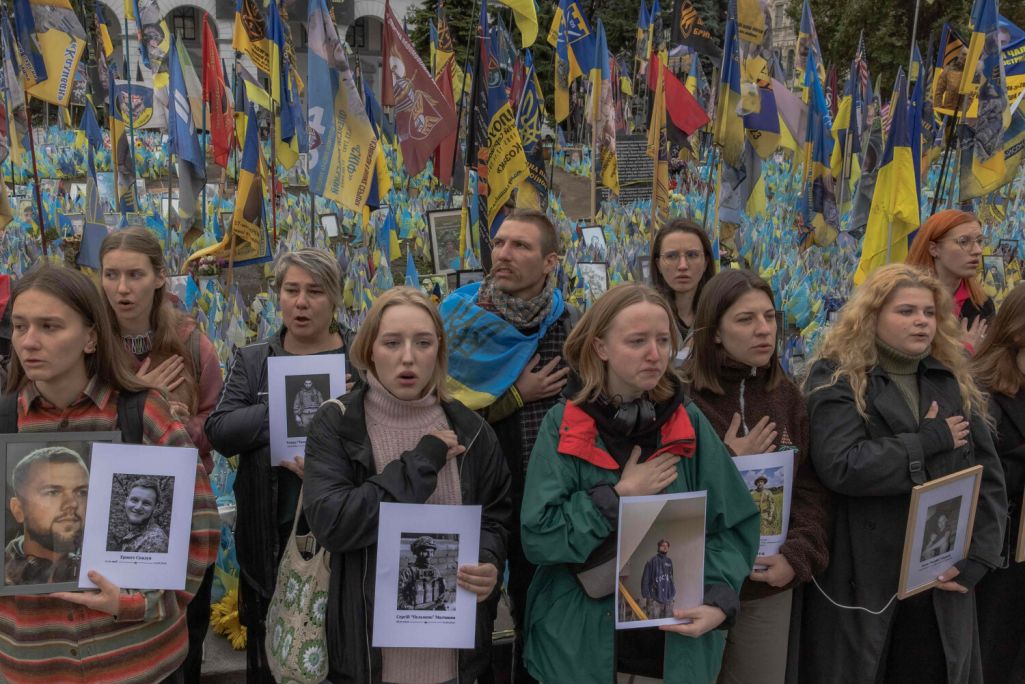 Падчас хвіліны маўчання ў памяць пра ўкраінскіх і замежных байцоў, якія загінулі падчас расейска-ўкраінскай вайны, украінцы спяваюць гімн у Дзень абаронцаў Украіны на Майдане незалежнасці. Кіеў, Украіна. 1 кастрычніка 2024 года. Фота Roman Pilipey / AFP / East News