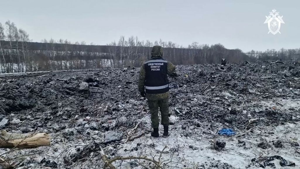 Супрацоўнік Следчага камітэту Расеі аглядае месца крушэння вайскова-транспартнага самалёта Іл-76. Белгародская вобласць, Расея. 25 студзеня 2024 года. (Фота: Handout / Russian Investigative Committee / AFP / East News)
