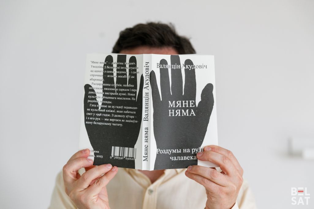 Павел Анціпаў трымае ў руках кнігу «Мяне няма: роздумы на руінах чалавека» Валянціна Акудовіча. (Фота: Таццяна Верамеева / Белсат)